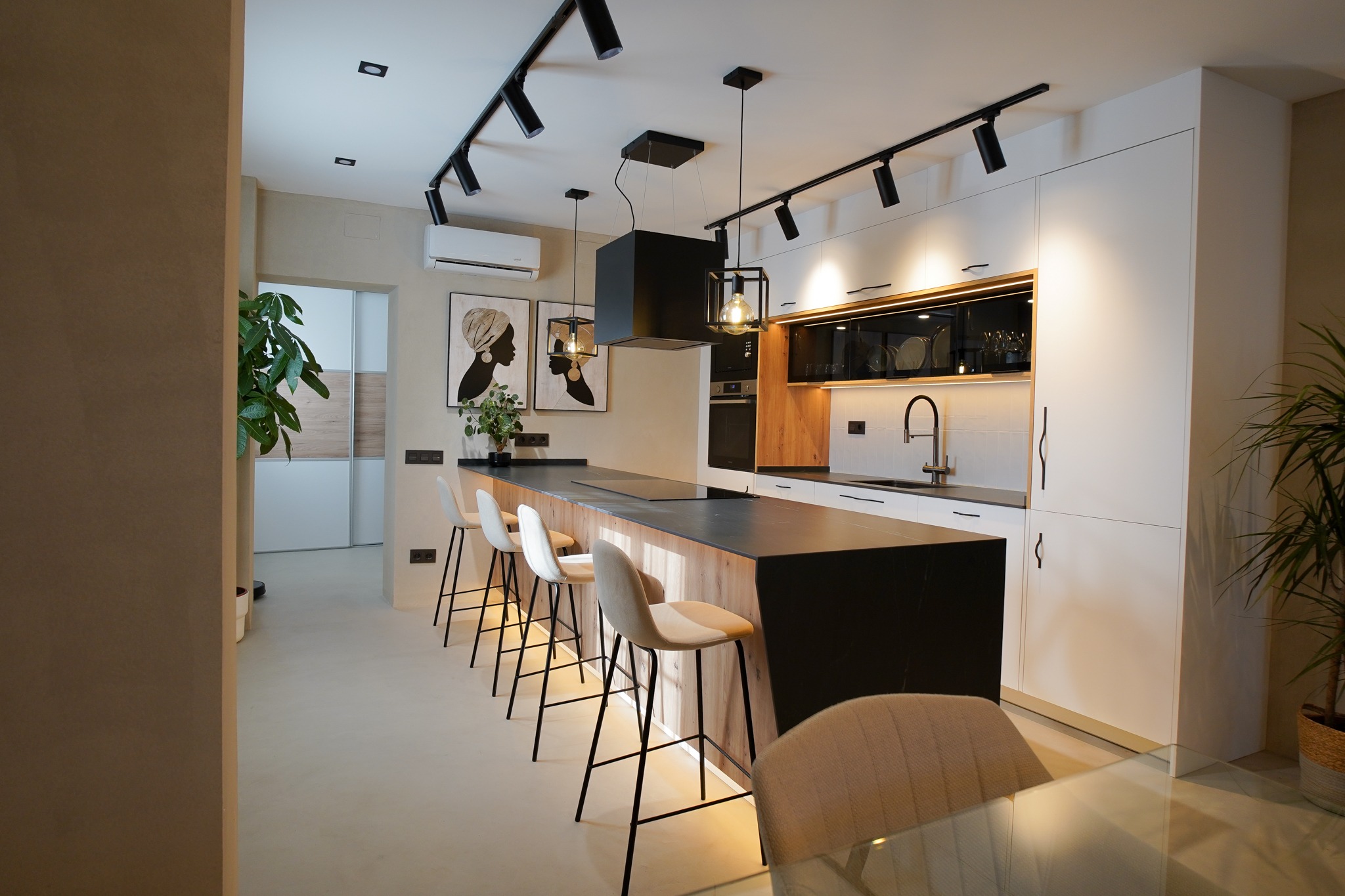 Cocina con isla, acabados de madera y encimera negra